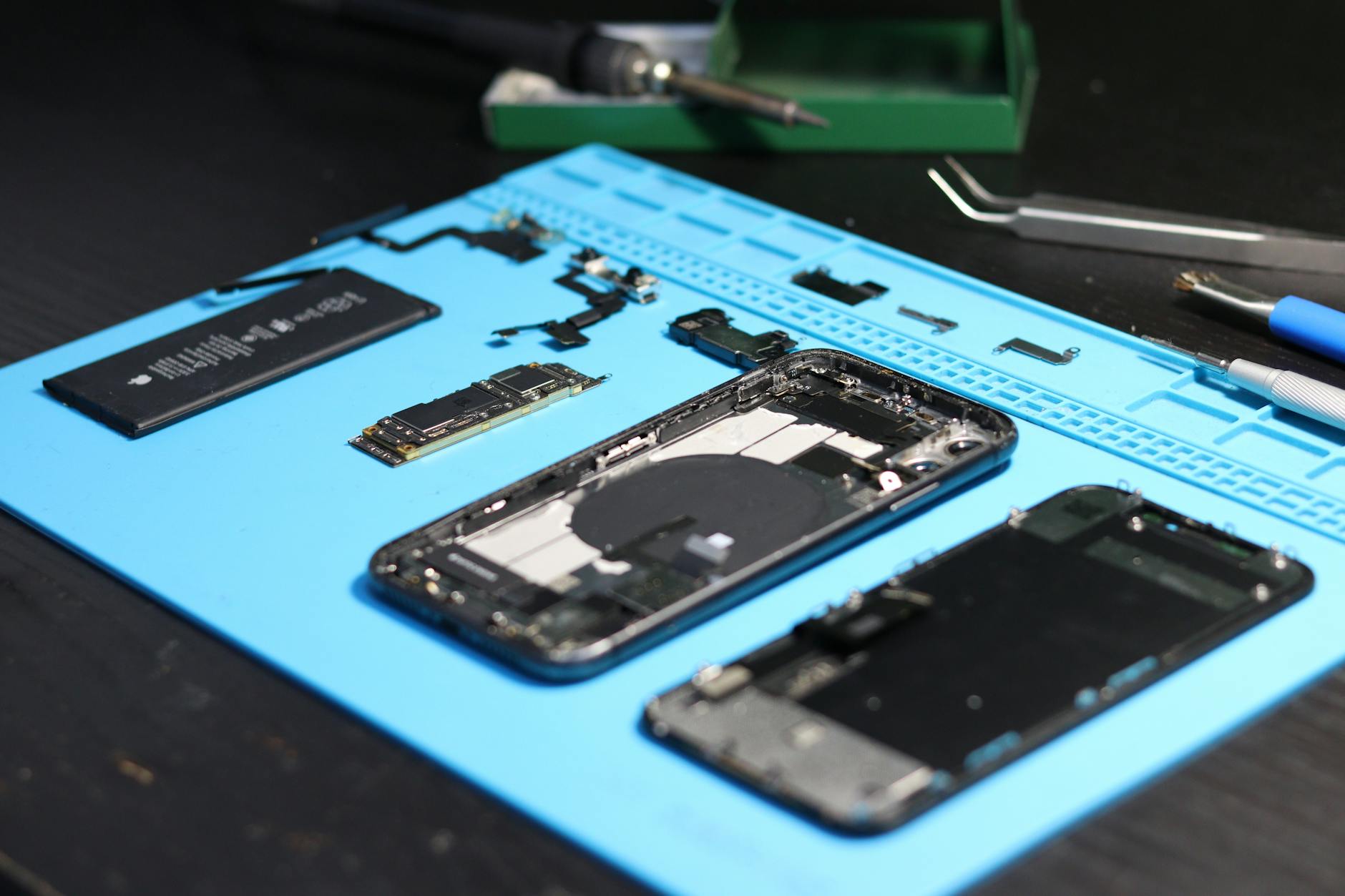 A robotic diagnostic enclosure inspecting a smartphone, representing automated grading workflows on a refurbishment floor.