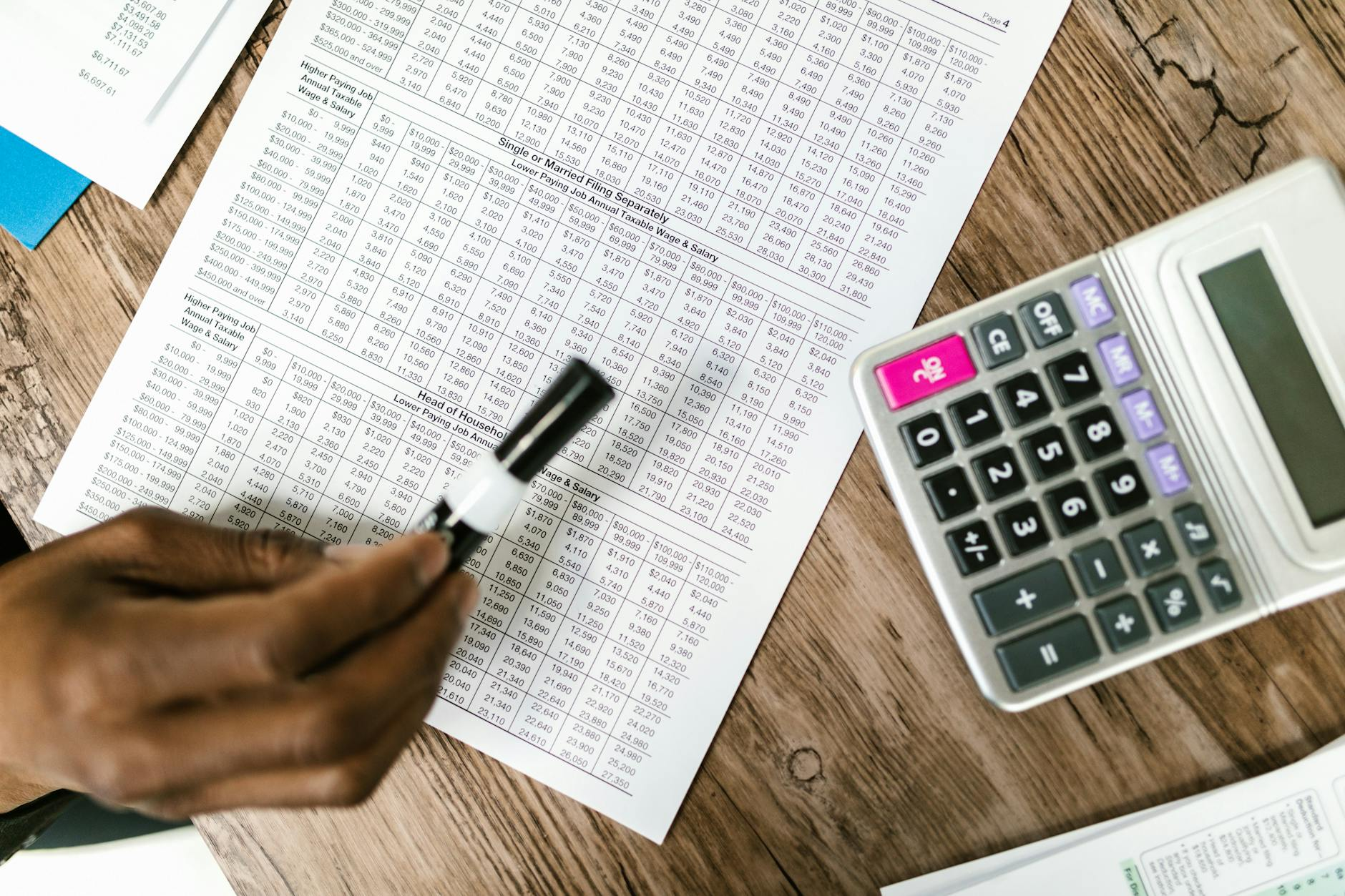 Calculator and spreadsheet on a finance professional's desk, illustrating the annualised cost of B2B platform fees.