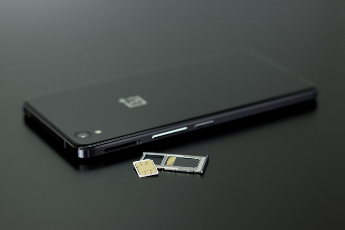 Primer plano de un teléfono inteligente al que se le han quitado la tarjeta SIM y la tarjeta de memoria.