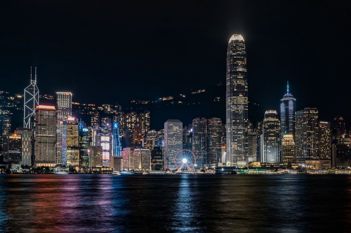 Una vista nocturna del horizonte de Hong Kong reflejándose sobre el puerto Victoria.