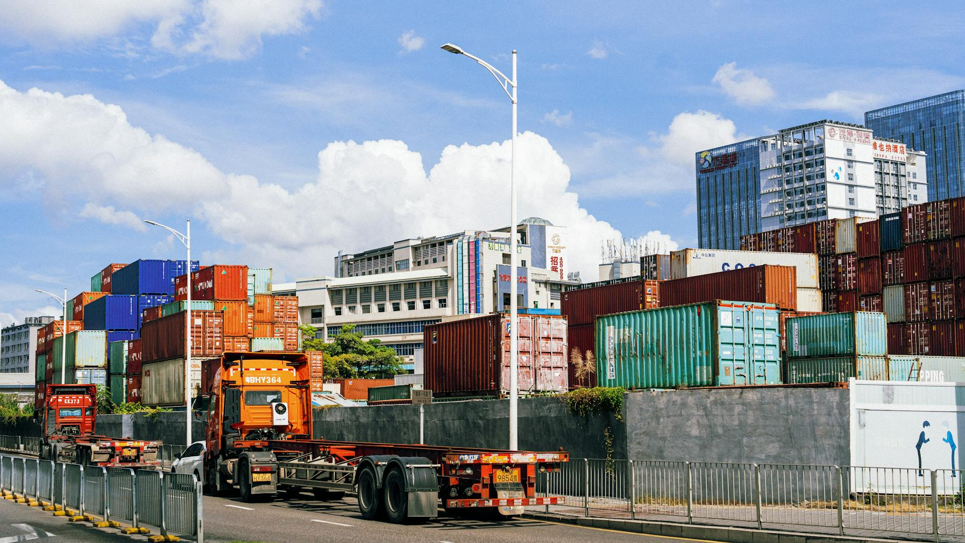 Stacked shipping containers at an industrial port, illustrating wholesale electronics logistics.
