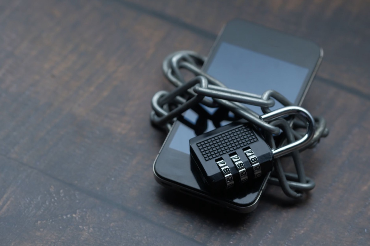 Un teléfono inteligente envuelto en una cadena con un candado, que simboliza un dispositivo bloqueado.