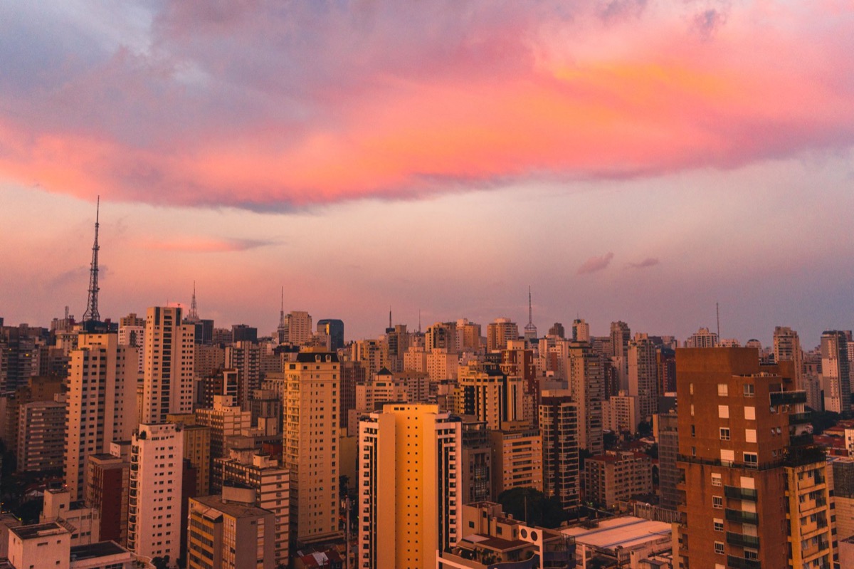 El horizonte de Sao Paulo al atardecer con vibrantes nubes rosas y naranjas.