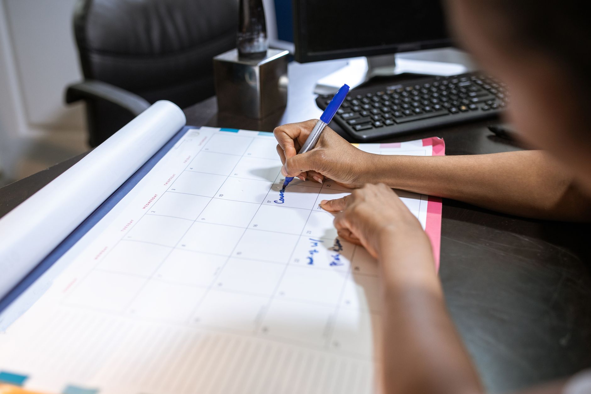 A desk calendar being used to plan a schedule.