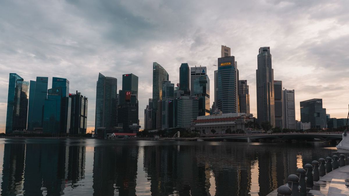 El horizonte de Singapur se refleja en el paseo marítimo al atardecer.
