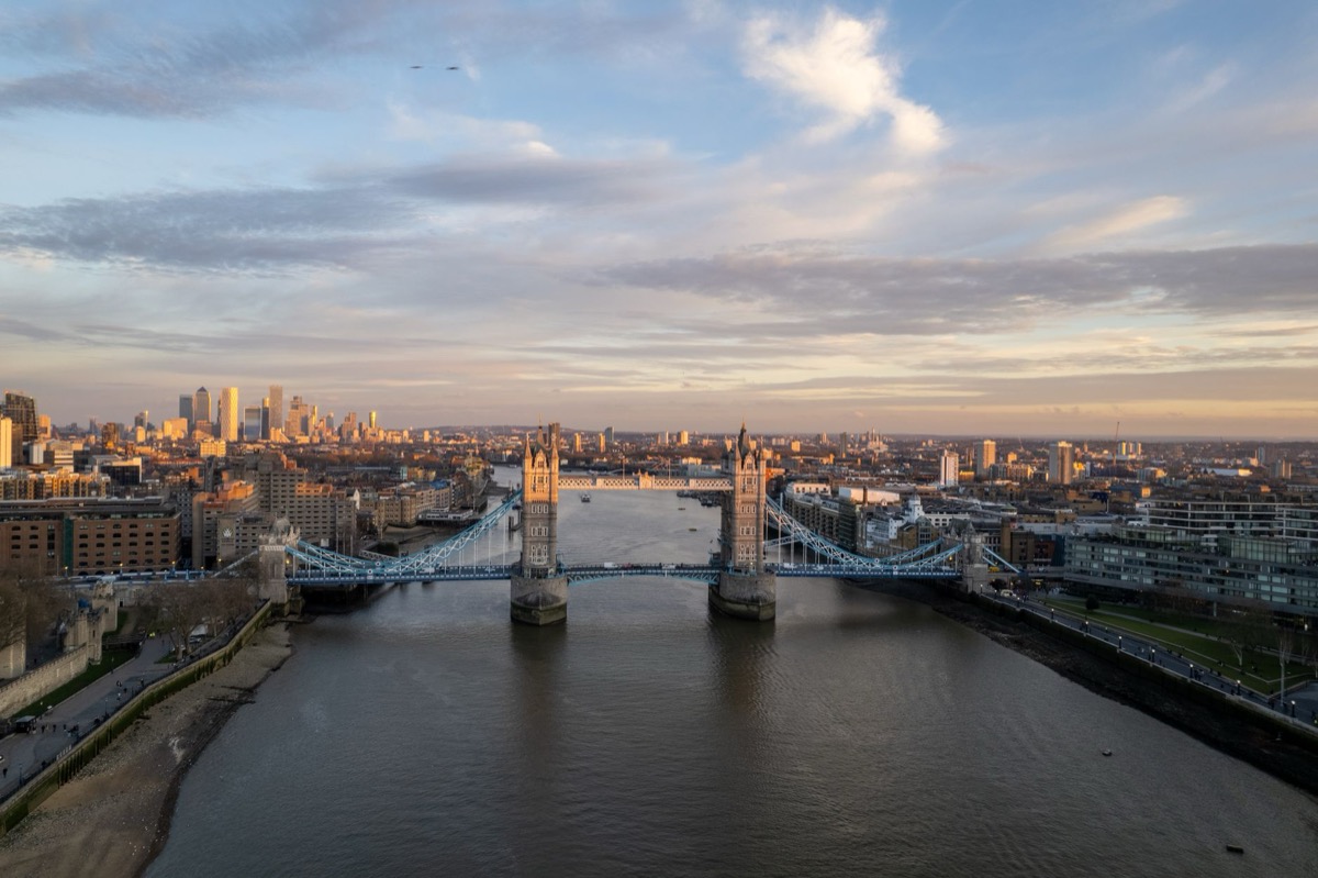 Una toma aérea del Tower Bridge de Londres con el horizonte de la ciudad al atardecer.
