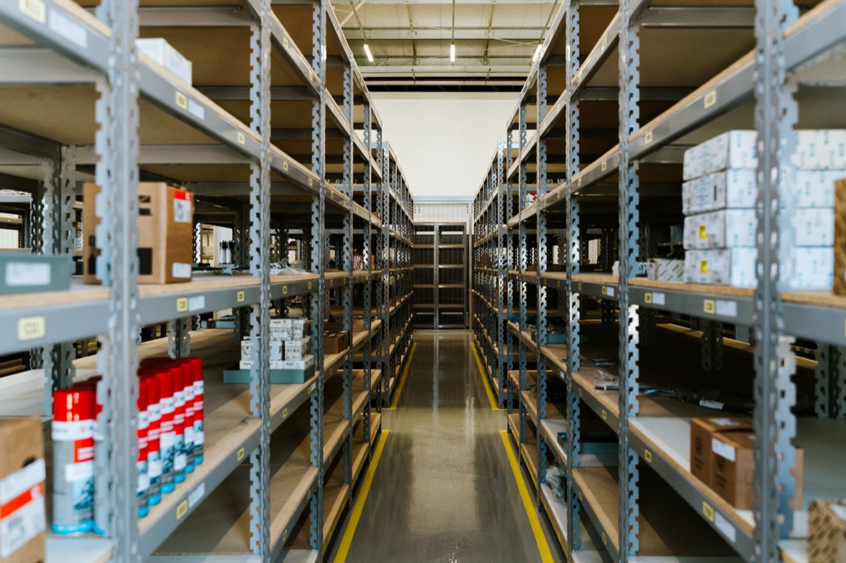 Una visión amplia de una nave industrial organizada con estanterías metálicas y mercancía almacenada.